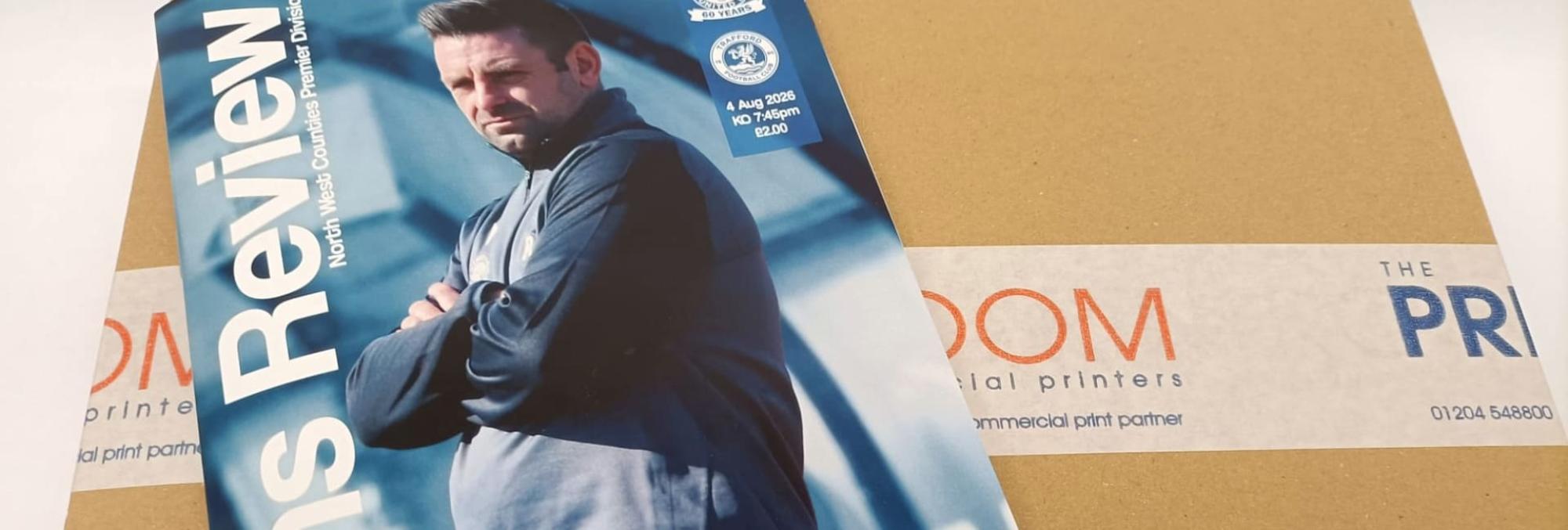 Ramsbottom United FC matchday programme on top of The Print Room's delivery packaging
