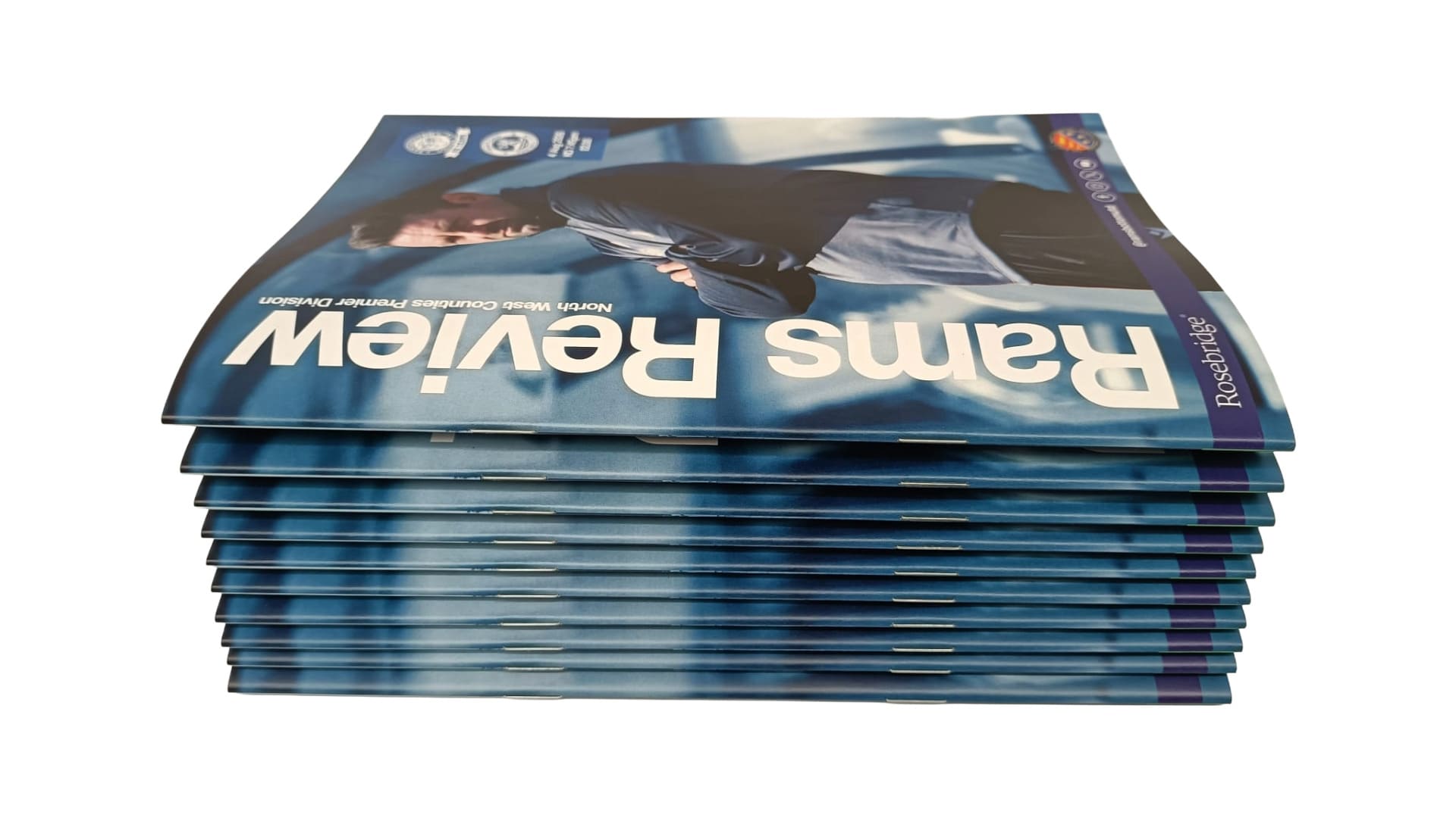 Ramsbottom United FC matchday programmes stacked on top of each other.